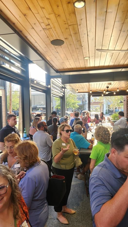 A full crowd of local professionals networking on the patio at 24 Middleton
